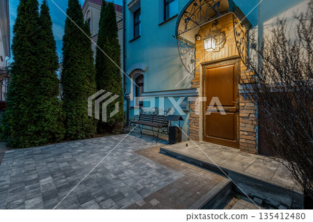 Evening entrance to luxury house with wooden door and lantern 135412480