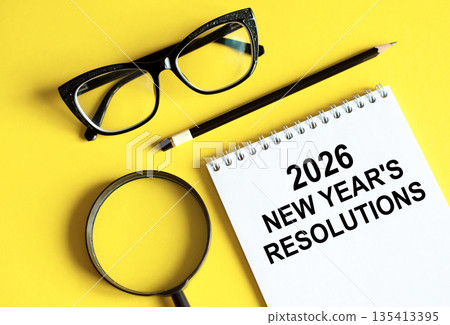 Business and finance concept - notebook with pencils glasses magnifier 135413395