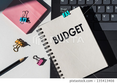 Notebook with tools and notes about BUDGET lies on laptop. Notebook with tools and notes about BUDGET lies on laptop. 135413408