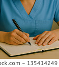 A woman working as a caregiver takes notes in a notebook 135414249