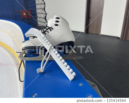 skates and skate blade guards on the ice arena board skates and skate blade guards on the ice arena board 135414564