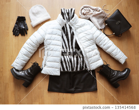 Autumn and winter stylish woman's outfit. Stylish Winter Outfit Flat Lay with Puffer Jacket and Combat Boots, Sweater, hat  and accessory. Top view 135414568