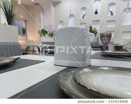 a napkins holder on table with dishes a napkins holder on table with dishes 135414806