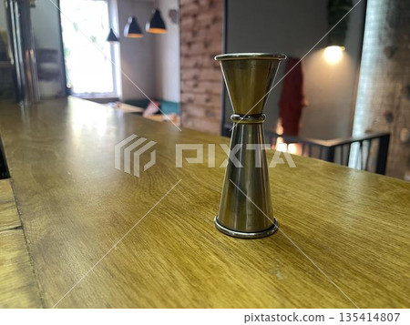 a measuring cup on the bar counter a measuring cup on the bar counter 135414807