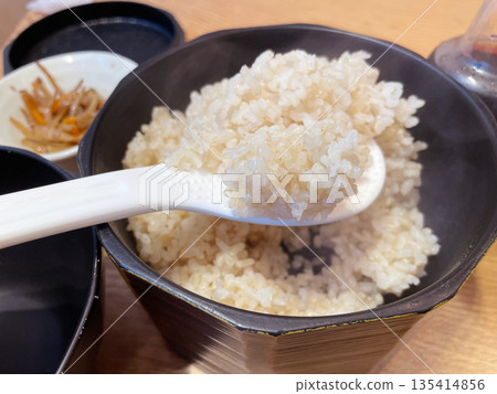 Brown rice in a wooden rice container; healthy brown rice in a wooden container. Brown rice in a wooden rice container; healthy brown rice in a wooden container. 135414856