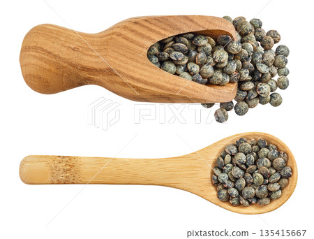 raw french green lentils in wooden spoon and scoop isolated on white background. Top view. Flat lay raw french green lentils in wooden spoon and scoop isolated on white background. Top view. Flat lay 135415667