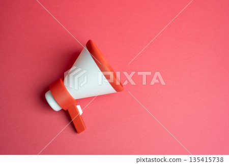 Megaphone on a red background. Marketing and advertising. High visibility promotion concept, urgency messaging, aggressive campaigns and emotional impact on audience attention and buying behavior Megaphone on a red background. Marketing and advertising. High visibility promotion concept, urgency messaging, aggressive campaigns and emotional impact on audience attention and buying behavior 135415738