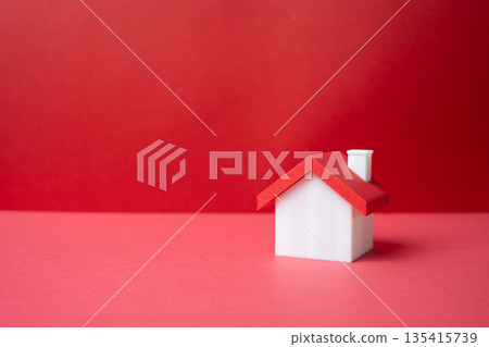 Minimalist house on a red background. Real estate and mortgages. Housing and rentals. Modern living concept, property financing, affordability issues and urban housing market dynamics Minimalist house on a red background. Real estate and mortgages. Housing and rentals. Modern living concept, property financing, affordability issues and urban housing market dynamics 135415739