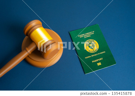Passport of the Republic of Nigeria and judge's gavel. Court and protection of the rights of citizens. Visa regulation, and migration law enforcement. Citizenship and right of residence. Passport of the Republic of Nigeria and judge's gavel. Court and protection of the rights of citizens. Visa regulation, and migration law enforcement. Citizenship and right of residence. 135415878