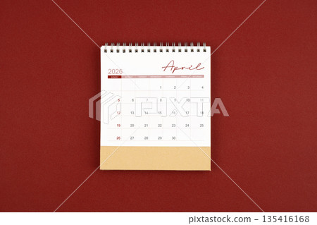 April 2026 desk calendar on red leather. 135416168