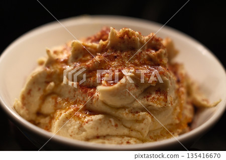 Traditional chickpea hummus with olive oil, spices, and fresh toppings. 135416670