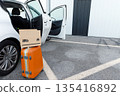 suitcases and boxes were lying on the ground next to the car. 135416892