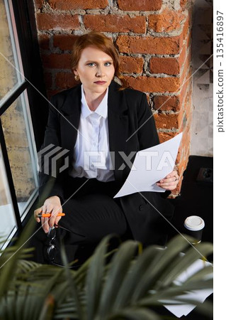 Financial professional assessing charts and quarterly data at desk 135416897