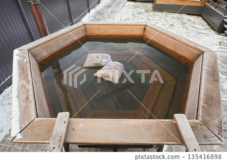 Intimate outdoor tub surrounded by warm timber accents and tranquil scenery 135416898
