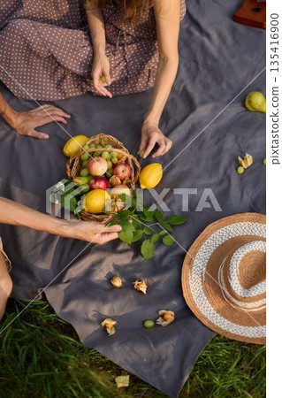 Sundrenched picnic scene featuring harvest fruits and casual gathering Sundrenched picnic scene featuring harvest fruits and casual gathering 135416900