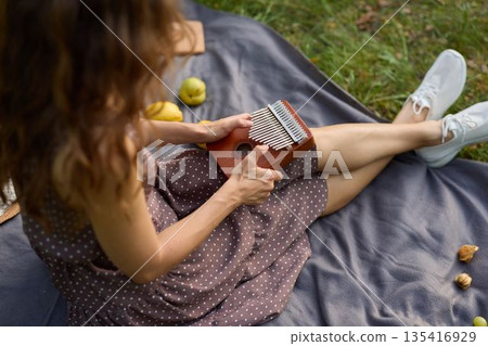 Woman writings outdoors, Outdoor scene of woman with notebook and hat Woman writings outdoors, Outdoor scene of woman with notebook and hat 135416929