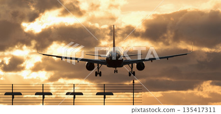 Plane landing . Silhouette of aircraft, back view. Silhouette of passenger aircraft airline on beautiful sunset background Plane landing . Silhouette of aircraft, back view. Silhouette of passenger aircraft airline on beautiful sunset background 135417311