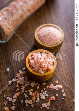Pink Himalayan salt in bowl on wooden table. Pink Himalayan salt in bowl on wooden table. 135417954