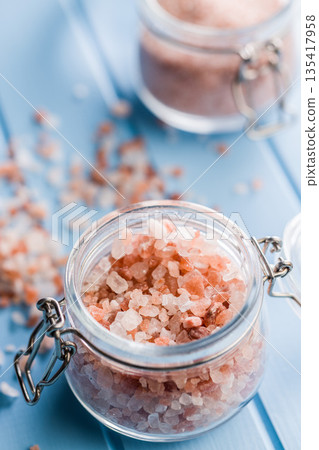 Pink Himalayan salt in jar on blue table. Pink Himalayan salt in jar on blue table. 135417958