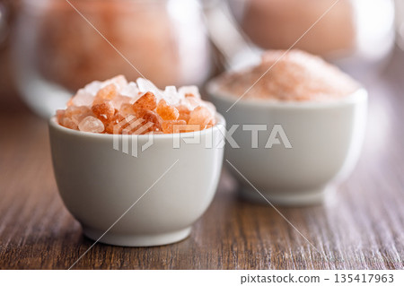 Pink Himalayan salt in bowl on wooden table. Pink Himalayan salt in bowl on wooden table. 135417963