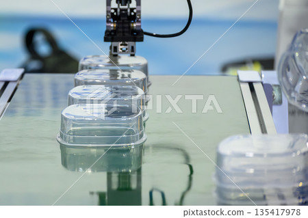 Plastic Food Containers on Conveyor Belt from Injection Molding Machine 135417978