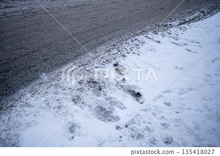 Snowfall and warming create slushy roads with salt dissolving snow into muddy mess. Winter road 135418027