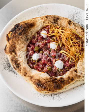 Elegant tartare pizza topped with golden fried potatoes and rich cream Elegant tartare pizza topped with golden fried potatoes and rich cream 135418208