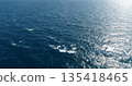 Blue ocean water surface texture. Aerial view of sea waves and sun reflection background. 135418465