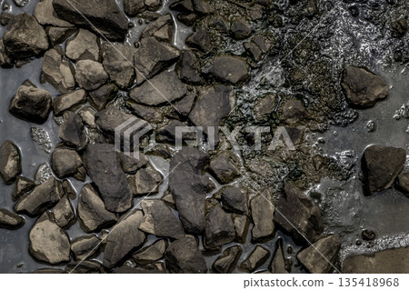 Ballast stone gravel soaked with engine oil in the railroad tracks. Ballast stone gravel soaked with engine oil in the railroad tracks. 135418968