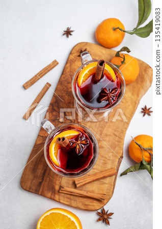 Two glasses of mulled wine, orange, cinnamon, and star anise on a wooden board Two glasses of mulled wine, orange, cinnamon, and star anise on a wooden board 135419083