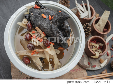 A revered staple in Chinese and Asian culinary traditions, the nourishing health stew pictured is widely celebrated as "Black Chicken Soup" also known as Stewed Black Bone Chicken or silkie chicken A revered staple in Chinese and Asian culinary traditions, the nourishing health stew pictured is widely celebrated as "Black Chicken Soup" also known as Stewed Black Bone Chicken or silkie chicken 135419514