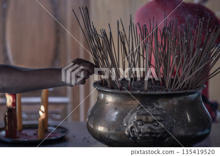 Incense burning at a temple in Wat Mangkon Kamalawat, Bangkok. Incense burning at a temple in Wat Mangkon Kamalawat, Bangkok. 135419520