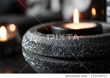 Concrete candle holder with black candle on a table setting at home Generative AI 135419751