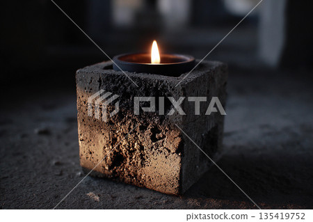 Concrete candle holder with black candle lit in a dim room setting Generative AI 135419752