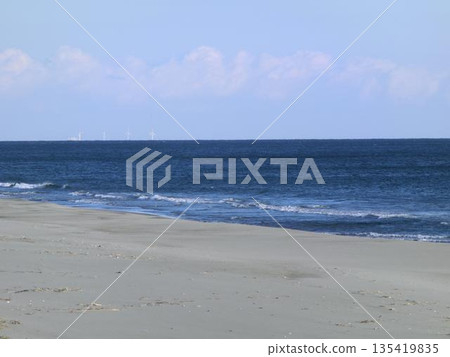 Waves crashing on the beach and a calm sky 135419835