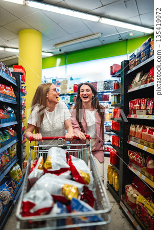 Friends enjoying a fun shopping experience in a bright grocery store Friends enjoying a fun shopping experience in a bright grocery store 135419972