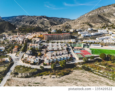 Aerial view of Relleu village surrounded by rugged mountains  135420522