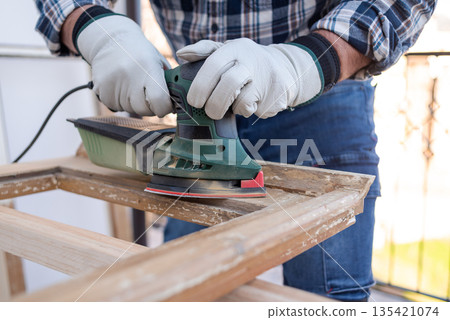 Carpenter at work, restoring an old wooden window. Carpentry. 135421074