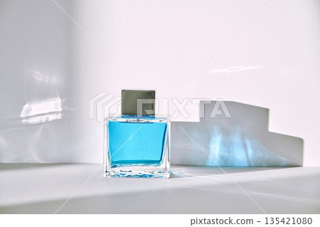 Perfume bottle with blue liquid and captivating shadows 135421080