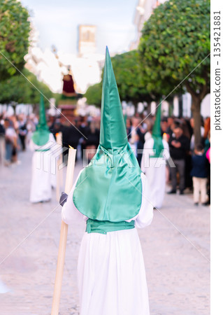 Nazarene walking in a holy week procession in Andalusia Spain holding a silver cross. Nazarene walking in a holy week procession in Andalusia Spain holding a silver cross. 135421881