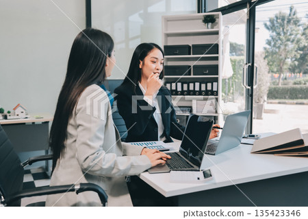 Businesswomen having discussion in office Businesswomen having discussion in office 135423346