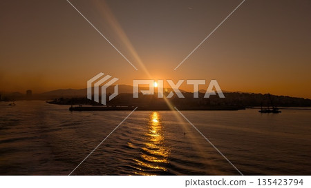 Sunrise behind the city and mountain on the Aegean Sea  135423794