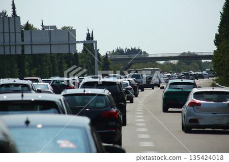 Heavy traffic congestion on highway with cars, tunnels, and traffic signals. 135424018