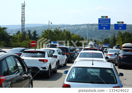 Heavy traffic congestion on highway with cars, tunnels, and traffic signals. 135424022
