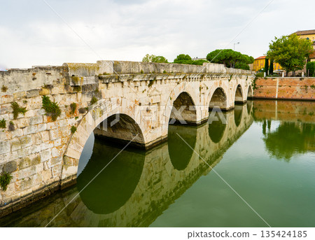 Tiberius Bridge over the river in Rimini. Italian classical architecture. A city landmark. Tiberius Bridge over the river in Rimini. Italian classical architecture. A city landmark. 135424185