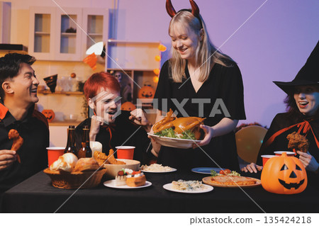Friends enjoying a Halloween party at a bar making a toast Friends enjoying a Halloween party at a bar making a toast 135424218