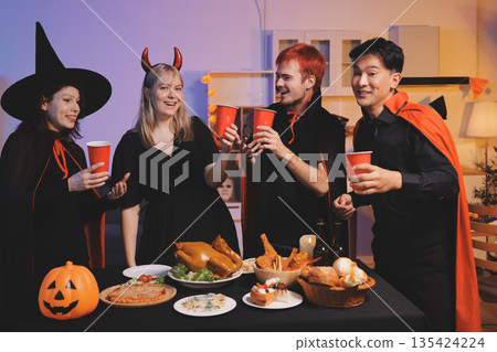 Friends enjoying a Halloween party at a bar making a toast 135424224