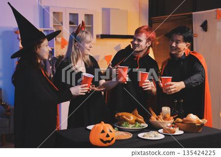 Friends enjoying a Halloween party at a bar making a toast Friends enjoying a Halloween party at a bar making a toast 135424225