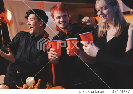Friends enjoying a Halloween party at a bar making a toast Friends enjoying a Halloween party at a bar making a toast 135424227