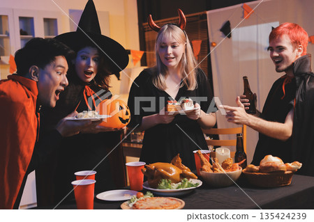 Friends enjoying a Halloween party at a bar making a toast 135424239